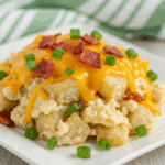 A serving of warm Twice Baked Potato Casserole with green onions.